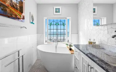 a white bathroom with a tub and a window at Memories at the Seashore in Panama City Beach