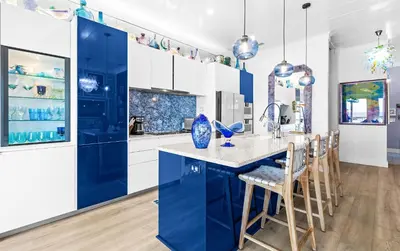 a blue kitchen with white cabinets and a blue island at Memories at the Seashore in Panama City Beach
