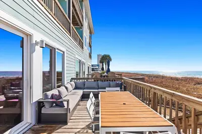 a porch with a couch and a table on the beach at Memories at the Seashore in Panama City Beach