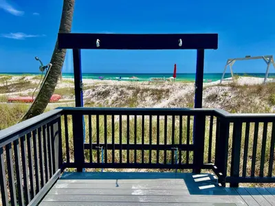 a bench on a boardwalk next to the beach at Modern Condo! Free Beach Chairs & Pools by Dolce Vita Getaways PCB in Panama City Beach