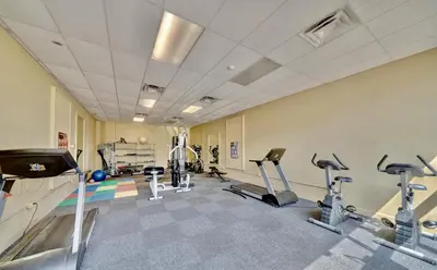 a gym with several treadmills and cardio machines at Modern Condo! Free Beach Chairs & Pools by Dolce Vita Getaways PCB in Panama City Beach