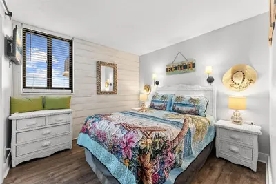 a bedroom with a large bed and a window at Modern Condo! Free Beach Chairs & Pools by Dolce Vita Getaways PCB in Panama City Beach