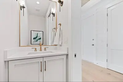 a white bathroom with a sink and a mirror at Golf Cart, Big pool, Bikes, Pets OK, Walk 2 Beach! in Santa Rosa Beach