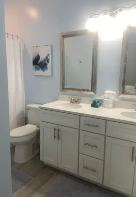a bathroom with a sink and a toilet and a mirror at Livin Laguna Loca in Panama City Beach