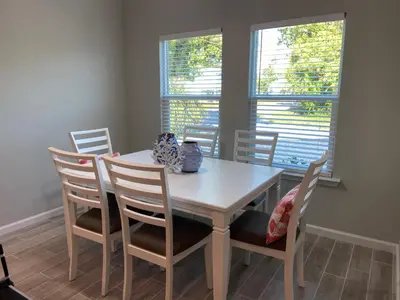 a dining room with a white table and chairs at Livin Laguna Loca in Panama City Beach