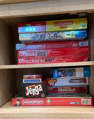 a stack of board games on a shelf at Livin Laguna Loca in Panama City Beach