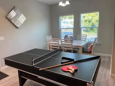 a ping pong table in a living room with a dining room at Livin Laguna Loca in Panama City Beach