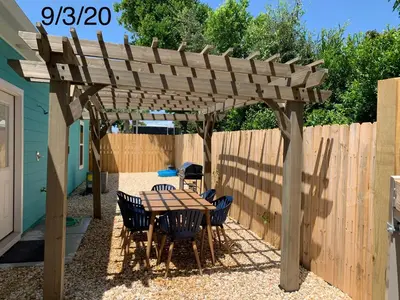 a wooden pergola with a table and chairs under it at Livin Laguna Loca in Panama City Beach