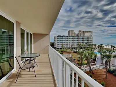 a balcony with a table and chairs and a view of the ocean at Dunes of Panama #B301 in Panama City Beach