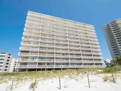 a tall building on the beach next to the sand at Dunes of Panama #B301 in Panama City Beach