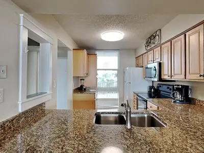 a kitchen with a sink and a refrigerator at Dunes of Panama #B301 in Panama City Beach