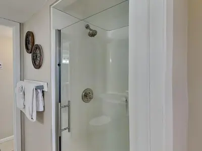 a shower with a glass door in a bathroom at Dunes of Panama #D702 in Panama City Beach