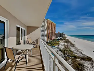 a balcony with a table and chairs and the beach at Dunes of Panama #D702 in Panama City Beach