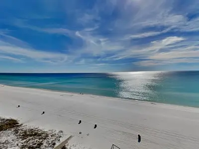 a beach with people walking on the sand and the ocean at Dunes of Panama #D702 in Panama City Beach