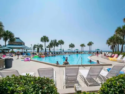 a pool with chairs and people in the water at Dunes of Panama #D702 in Panama City Beach