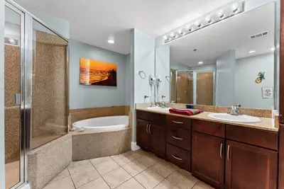 a bathroom with two sinks and a shower at 3 BD Gulf View Resort Condo! 5 Pools! Beach Access by Dolce Vita Getaways in Panama City Beach