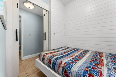 a bedroom with a bed in a white wall at 3 BD Gulf View Resort Condo! 5 Pools! Beach Access by Dolce Vita Getaways in Panama City Beach