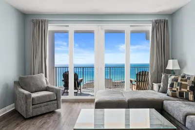 a living room with a view of the ocean at 3 BD Gulf View Resort Condo! 5 Pools! Beach Access by Dolce Vita Getaways in Panama City Beach
