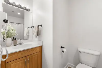 a bathroom with a sink and a toilet and a mirror at Shores of Panama Ground Floor Unit 108! No elevators needed and convenient same-floor parking! in Panama City Beach