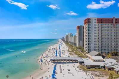 an aerial view of a beach with buildings and the ocean at Shores of Panama Ground Floor Unit 108! No elevators needed and convenient same-floor parking! in Panama City Beach