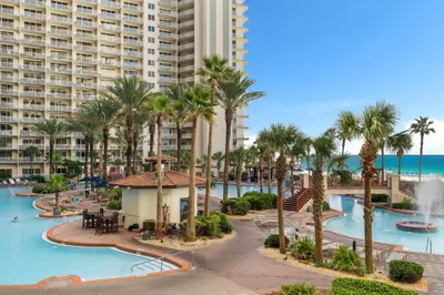 a view of the pool at a resort with palm trees at Shores of Panama Ground Floor Unit 108! No elevators needed and convenient same-floor parking! in Panama City Beach