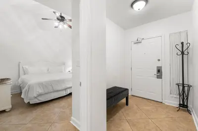 a white bedroom with a bed and a ceiling fan at Shores of Panama Ground Floor Unit 108! No elevators needed and convenient same-floor parking! in Panama City Beach