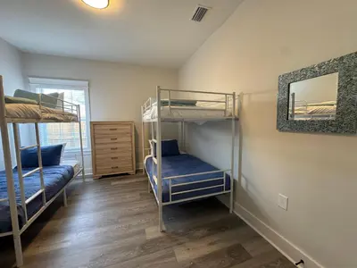 a bedroom with two bunk beds and a mirror at BeaLake House in Panama City Beach
