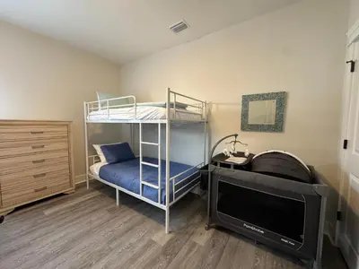 a bedroom with a bunk bed and a flat screen tv at BeaLake House in Panama City Beach