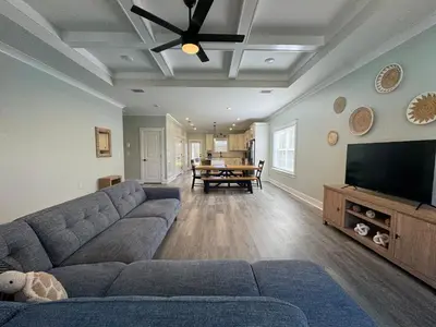 a living room with a couch and a flat screen tv at BeaLake House in Panama City Beach