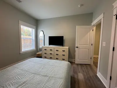 a bedroom with a bed and a television on a dresser at BeaLake House in Panama City Beach