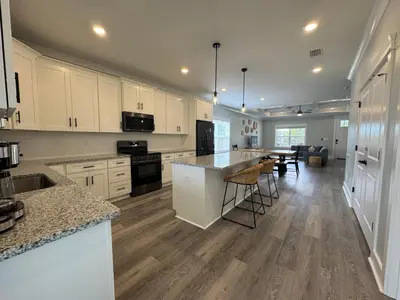 a large kitchen with white cabinets and a counter top at BeaLake House in Panama City Beach