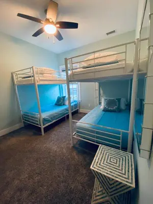 two bunk beds in a room with a ceiling fan at Reverie Riviera in Panama City Beach