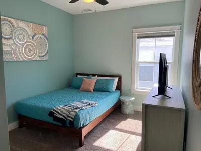 a bedroom with a bed and a television in it at Reverie Riviera in Panama City Beach