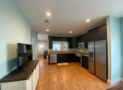 a kitchen with black cabinets and stainless steel appliances at Reverie Riviera in Panama City Beach