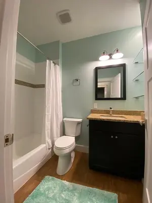 a bathroom with a toilet and a sink and a mirror at Reverie Riviera in Panama City Beach