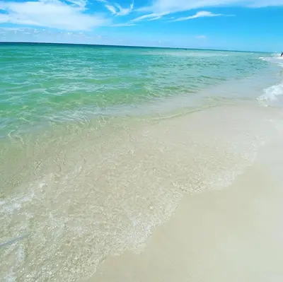a sandy beach with the ocean in the background at Reverie Riviera in Panama City Beach