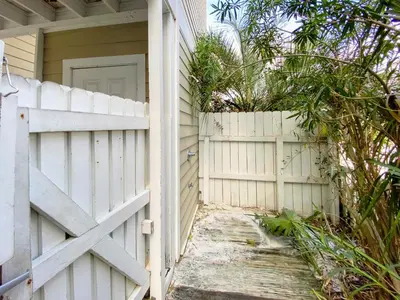 an entrance to a house with a white fence at Leeward II 9 l Beachfront Corner Condo l Views of the Water l Sunset Views in Seagrove Beach
