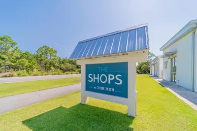 a sign in the grass in front of a building at Leeward II 9 l Beachfront Corner Condo l Views of the Water l Sunset Views in Seagrove Beach