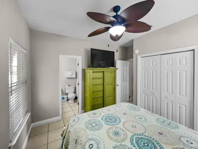 a bedroom with a bed and a ceiling fan at Paradise by the Pier l Ocean Views l Dog Friendly l Steps to Pier Park Shopping and Restaurants in Panama City Beach