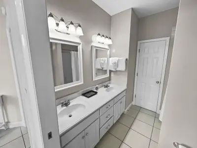 a white bathroom with a sink and a mirror at Paradise by the Pier l Ocean Views l Dog Friendly l Steps to Pier Park Shopping and Restaurants in Panama City Beach