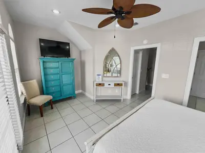 a bedroom with a blue dresser and a ceiling fan at Paradise by the Pier l Ocean Views l Dog Friendly l Steps to Pier Park Shopping and Restaurants in Panama City Beach