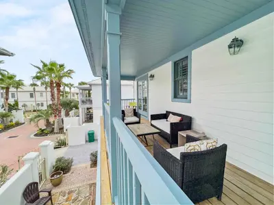 a balcony with wicker chairs and tables on a house at Mare e Sole l Steps to the Beach l South of 30A l Beachfront Pool l 2 Bikes included in Rosemary Beach