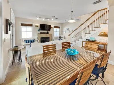 a dining room and living room with a table and chairs at Mare e Sole l Steps to the Beach l South of 30A l Beachfront Pool l 2 Bikes included in Rosemary Beach
