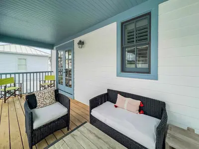 a porch with two wicker chairs and a window at Mare e Sole l Steps to the Beach l South of 30A l Beachfront Pool l 2 Bikes included in Rosemary Beach