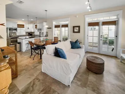 a living room with a white couch and a kitchen at Mare e Sole l Steps to the Beach l South of 30A l Beachfront Pool l 2 Bikes included in Rosemary Beach