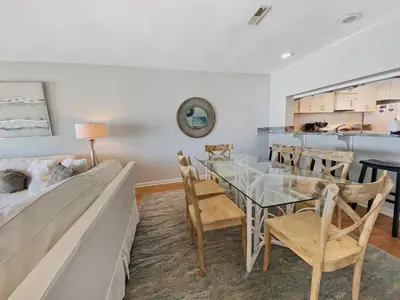 a dining room with a glass table and chairs at On the Beach l Beach Front l Steps to the Beach l 2 Bikes Included in Inlet Beach