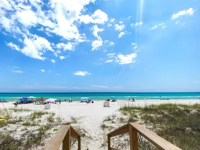 a beach with people on the sand and the ocean at On the Beach l Beach Front l Steps to the Beach l 2 Bikes Included in Inlet Beach
