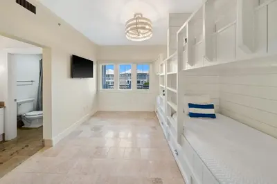 a bathroom with a toilet and a television on a wall at Paradise Loft l Luxury Beach Front Condo l Amazing Views in Santa Rosa Beach