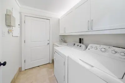 a white laundry room with white cabinets and white appliances at Paradise Loft l Luxury Beach Front Condo l Amazing Views in Santa Rosa Beach