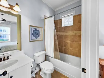 a white bathroom with a toilet and a sink at Pompano Palace l Bike or Walk to Rosemary l Gulf Views l Community Pool in Rosemary Beach